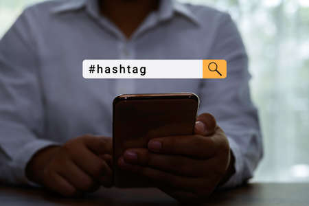 Person using a social media marketing concept on mobile phone with hashtag in search concept.の写真素材