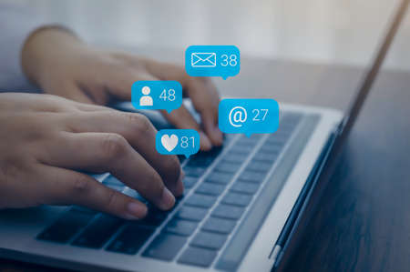Person using a social media marketing concept on computer laptop with notification icons of like,...