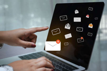 Businesswoman hand using laptop on table in office with new email alert sign icon pop-up. Mail communication connection message technology.の写真素材