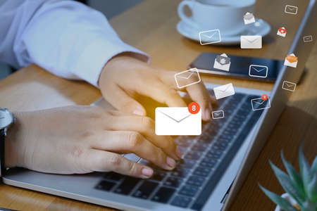 Businesswoman hand using laptop on table in office with new email alert sign icon pop-up. Mail communication connection message technology.の写真素材