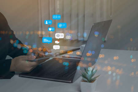 Person using a social media marketing concept on computer laptop with notification icons of like,...