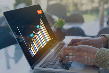 AR (Augmented reality) financial charts showing growing revenue in 2022 floating above digital...