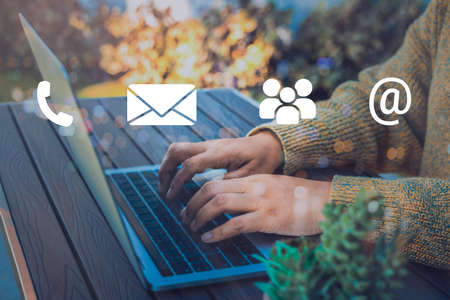 Contact us or Customer support hotline people connect. Businessman using a laptop with the (email, call phone, mail) icons.の写真素材
