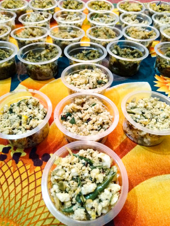 The image shows a table with a variety of food items in plastic containers. Each container has a different food item and is arranged on a table.の写真素材