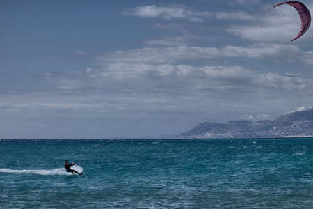 Kitesurfer in the sea against the backdrop of the mountainsの写真素材