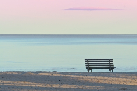 Bench on a sandy beach in the eveningの写真素材