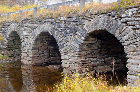 Old worn out stone arch bridge in Europe
