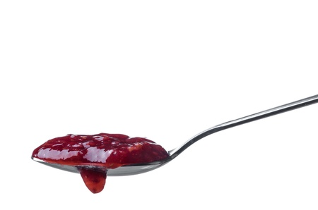 Raspberry jam dripping from a spoon isolated on white backgroundの写真素材
