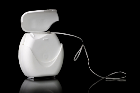 An open box of dental floss on black backgroundの写真素材