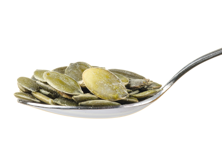 Pumpkin seeds in a spoon isolated on white backgroundの写真素材