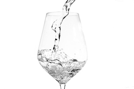 Pouring fresh water into a glass isolated on white の写真素材