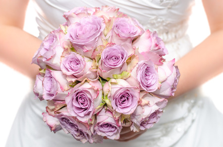 Bride in white dress holding purple wedding bouquetの写真素材