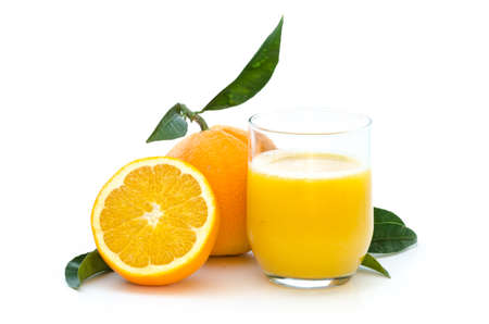 Oranges with fresh juice in a glass with leafs and stem on white backgroundの写真素材
