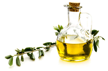 Olive oil in a bottle with a twig from an olive tree isolated on white backgroundの写真素材
