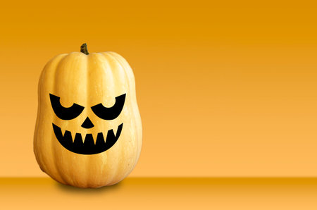 Halloween smile face pumpkin on a dark textured background. Autumn themed banner with space.の写真素材