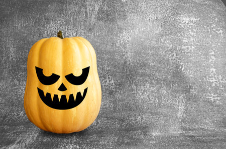 Halloween smile face pumpkin on a dark textured background. Autumn themed banner with space.の写真素材