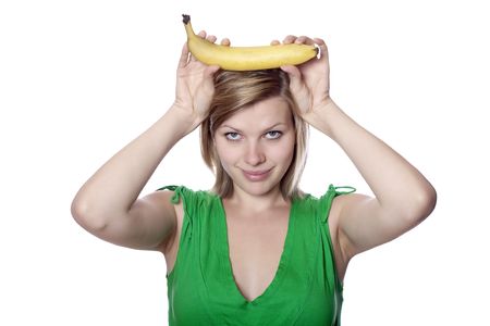 beautiful blonde young girl holding a banana like bull horns, isolated on whiteの写真素材