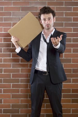 poor young unshaved businessman standing pleading with a blank signの写真素材