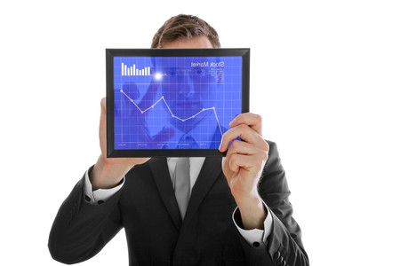 Businessman holding a touchpad pc, one finger touches the screen and checking the stock market, isolated on whiteの写真素材