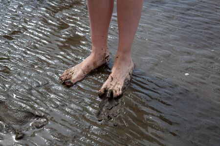 muddy feet during a walk in the wadden sea, the UNESCO World Heritage Site at the North Sea in...