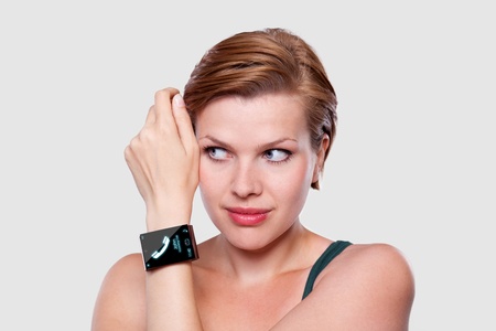 Girl with a modern Internet Smart Watch on grey background On the screen you can see a symbol of a call All Texts, Icons, Computer Interfaces of the Smart Watch where created from scratch by myself の写真素材