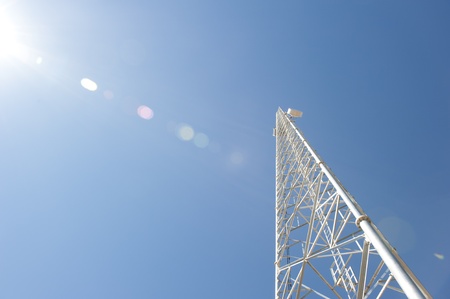 High rising steel structure of telecommunication tower for wireless transmission, with blue sky as background and copy space の写真素材