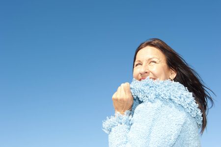 Portrait of confident and happy relaxed looking attractive senior woman enjoying active retirement in winter sunの写真素材
