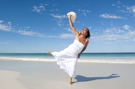 Sexy pretty middle aged woman cheerful, joyful in white summer dress at beach, isolated with ocean and blue sky as background and copy space.の写真素材