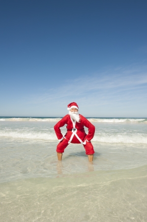 Santa Claus happy standing in shallow water at beachの写真素材