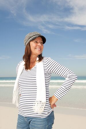 Portrait beautiful looking mature woman with happy smile, wearing sporty shirt and capの写真素材