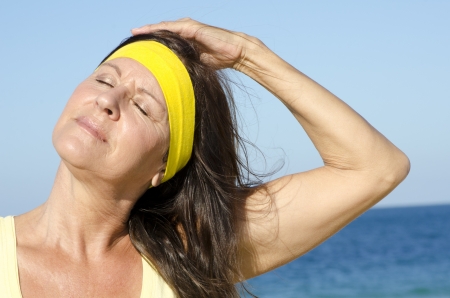 Portrait attractive and sporty fit mature woman relaxed with closed eyes enjoying sunny day outdoorの写真素材