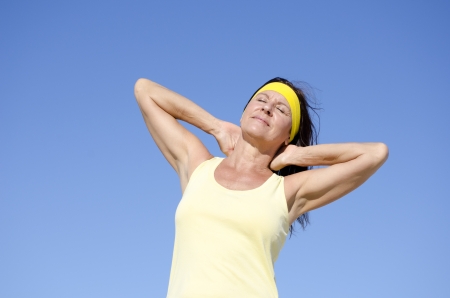 Portrait beautiful mature woman, happy, friendly, relaxed, healthy lifestyle, isolated with blue sky as background and copy space.の写真素材