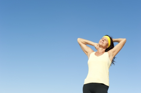Portrait beautiful mature woman, happy, friendly, relaxed, healthy lifestyle, isolated with blue sky as background and copy space.の写真素材