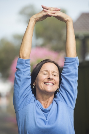 Portrait attractive mature woman happy relaxed with closed eyes outdoor, joyful smiling, daydreaming, thoughtful, isolated and blurred background.の写真素材
