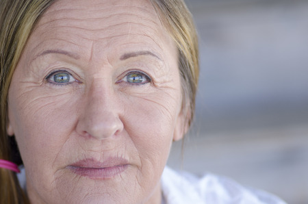 Portrait serious confident attractive mature woman relaxed posing, blurred background, copy space.の写真素材