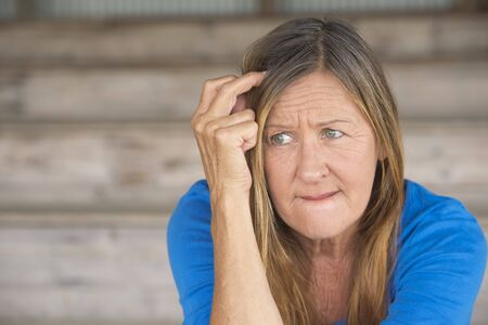 Portrait attractive mature woman with nervous thoughtful angry expression, lonely worried, blurred background.の写真素材
