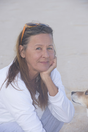 Portrait friendly attractive mature woman with curious dog pet friend looking at her outdoor.の写真素材