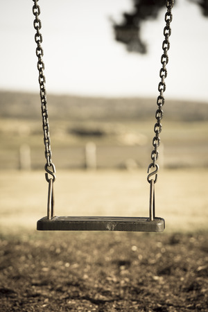 Concept image of Playground swing at park or garden with nobody, blurred background outdoor and copy spaceの写真素材