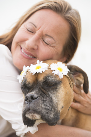Portrait Woman in blurred background with boxer dog pet friend cuddling, showing love and affection, friendship and happiness.の写真素材