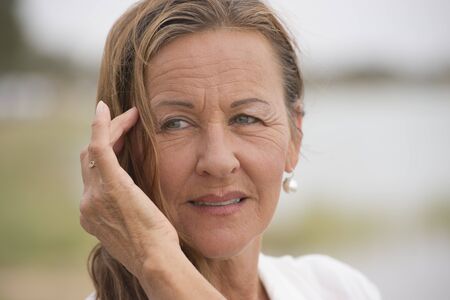 Portrait attractive single mature woman outdoor looking confident happy and relaxed, with bright...