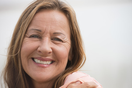 Portrait attractive mature woman happy relaxed, posing with joyful smile,, isolated with white outdoor background and copy space.の写真素材