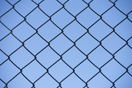 Security mesh fence, with texture on blue sky outdoor backgroundの写真素材
