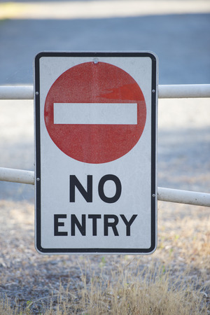 No entry sign on gate to restricted area of private property in blurred background