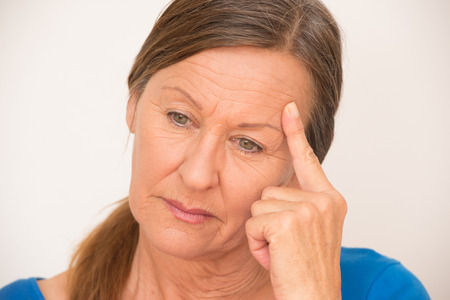 Portrait attractive mature woman thoughtful stressed worried look, isolated, bright background.の写真素材