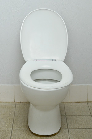 Filthy contaminated public water closet, with dirty tiles around bowl in messy restroom.の写真素材
