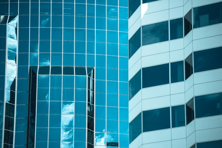 Conceptual filtered image of textured glass facade of modern design skyscraper office buildings in...