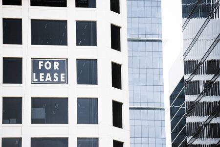 Conceptual image of Real Estate For Lease sign in window of business building, advertising vacant...