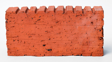 Construction brick of orange color made of burned clay isolated against white backgroundの写真素材