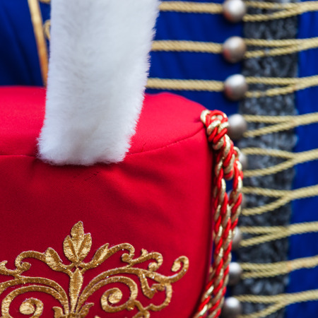 Details of red hussar busby hat with white fur plume against the background of blue dolman jacket. Napoleon wars era military uniform.の写真素材