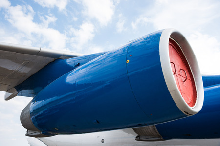 Blue side engine nacelle of a modern turbo-jet heavy aircraft. Pale blue sky and white clouds in the backgroundの写真素材
